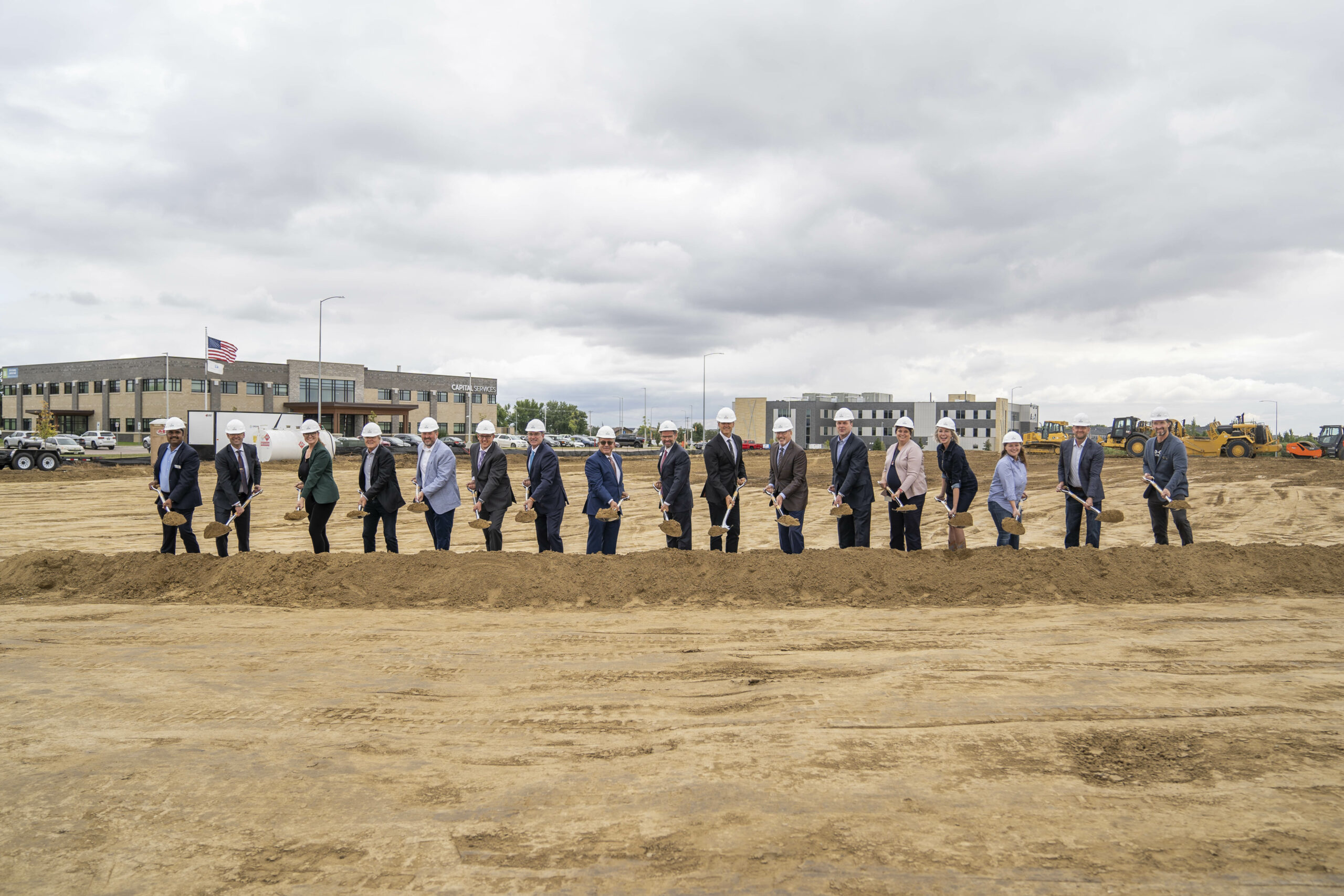 South Dakota State officials and contractors shovel dirt at the groundbreaking ceremony